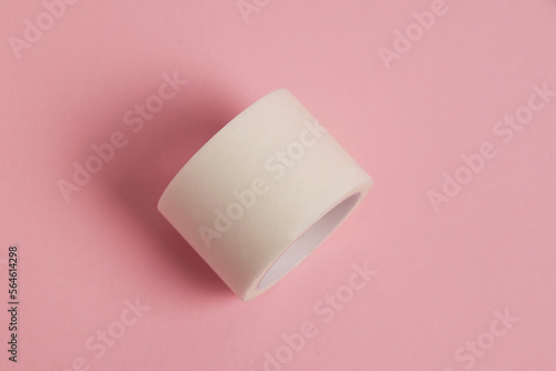White medical patch on a paper base, for applying bandages, on a pink background