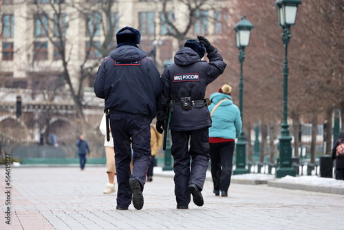Russian police officers patrol a city street in Moscow in winter. Translation of inscription on the human back: "Ministry of Internal Affairs of Russia"