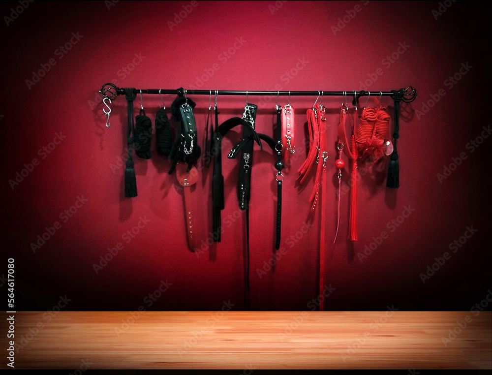 Whips for BDSM on red background in darkside. Accessory for sexual