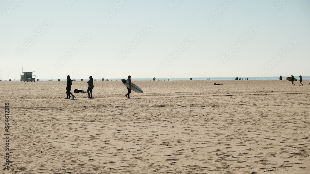 Persona surfista che cammina in spiaggia a Venice Beach