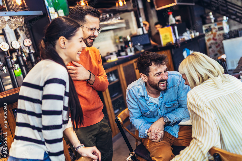 Young people have a great time in a cafe. Friends sitting in a coffee shop, drinking coffee, and having fun together.