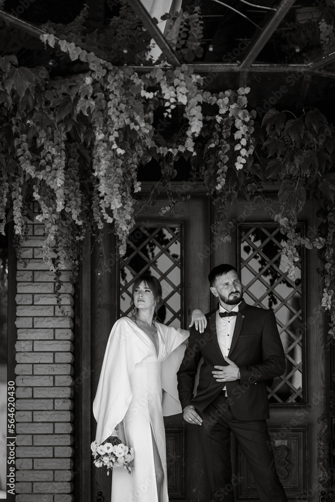 Fototapeta premium bride in a white dress with a bouquet and the groom in a blue suit