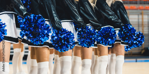 Billede på lærred Blue pom-poms being held by the cheerleaders standing in line