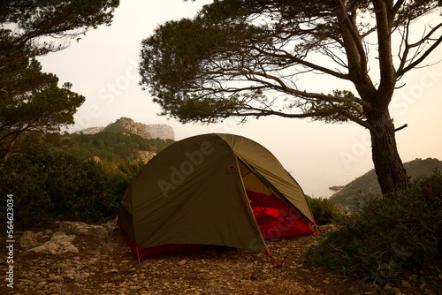 zwei personen Zelt aufgestellt auf einer Anhöhe nahe der Küste auf Mallorca entlang der Tramuntrana langstrecken Wanderweges mit Dunst im Hintergrung