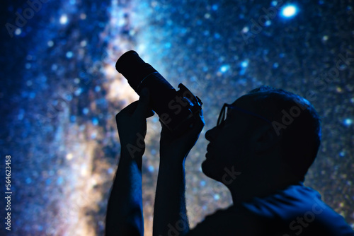 Astronomer photographing Milky Way night sky with a camera.