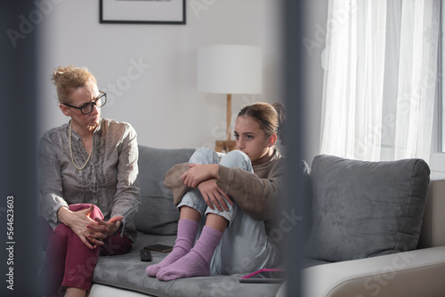 Mother talking with difficult teenager daughter at home.