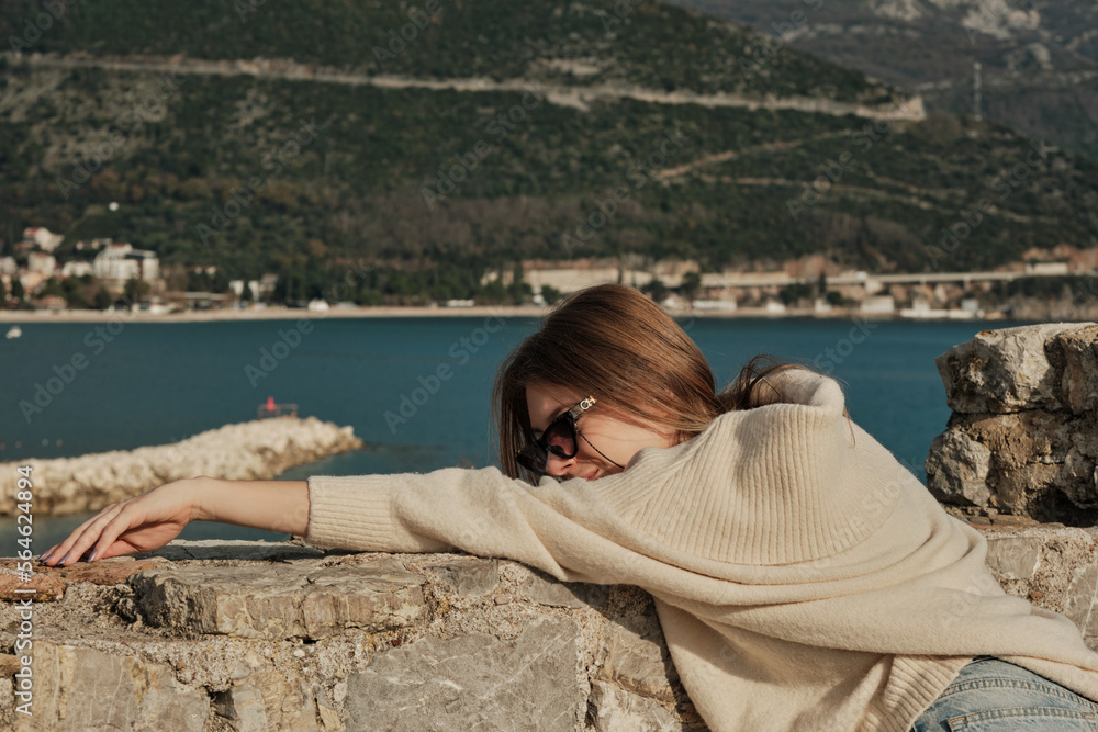 The girl lay down on a stone wall and closed her eyes The girl lay down on a stone wall and closed her eyes