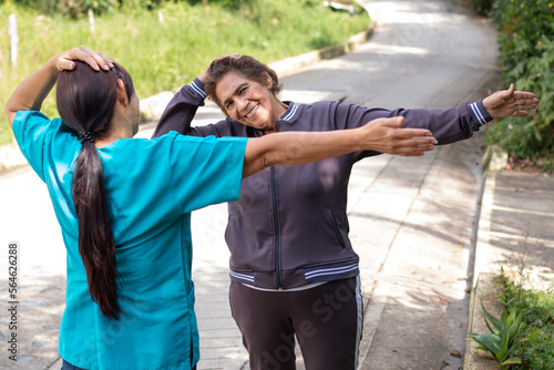 Fototapeta Nurse guiding an elderly woman in exercises to strengthen the neck and improve flexibility