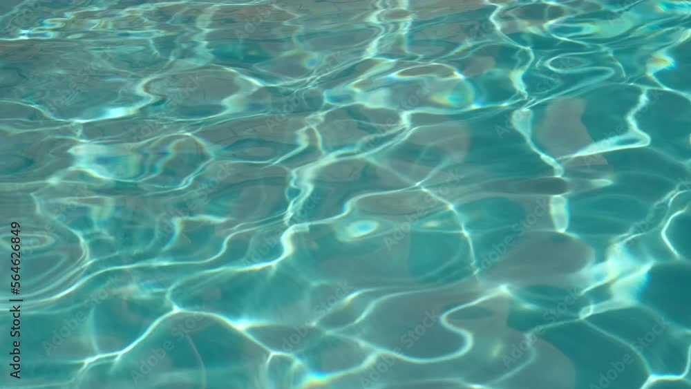Pure light turquoise water in swimming pool with sun reflections. Rippled water surface background Pure light turquoise water in swimming pool with sun reflections. Rippled water surface background