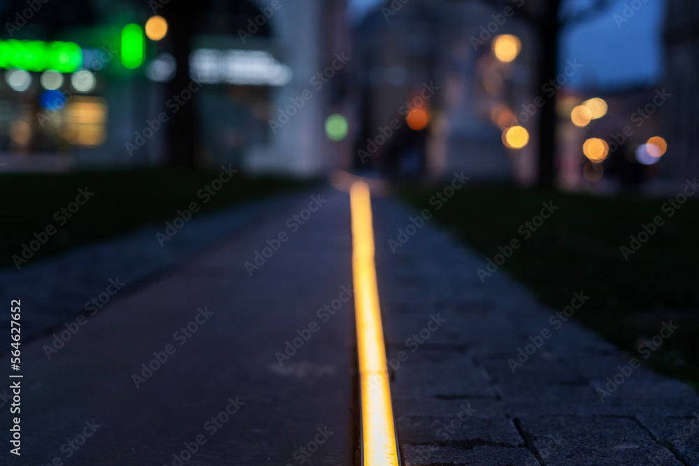 Illuminated sidewalk with led solar in a European city. Night city background Illuminated sidewalk with led solar in a European city. Night city background
