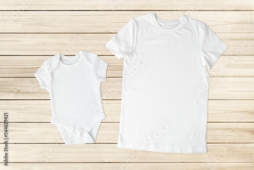 Set of mom's or dad's t-shirt and baby bodysuit mockup for design presentation, top view, wooden background.