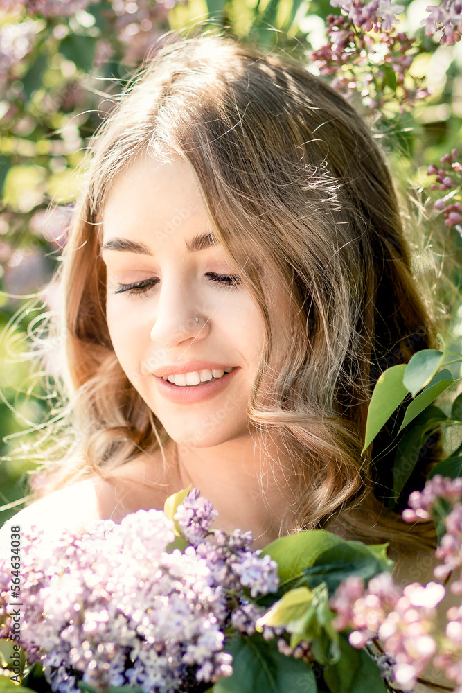 Portrait of a smiling young girl in blooming lilac trees. Summer time,vacation Portrait of a smiling young girl in blooming lilac trees. Summer time,vacation