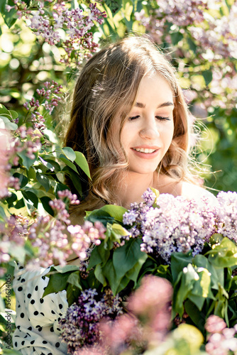 Portrait of a smiling young girl in blooming lilac trees. Summer time,vacation