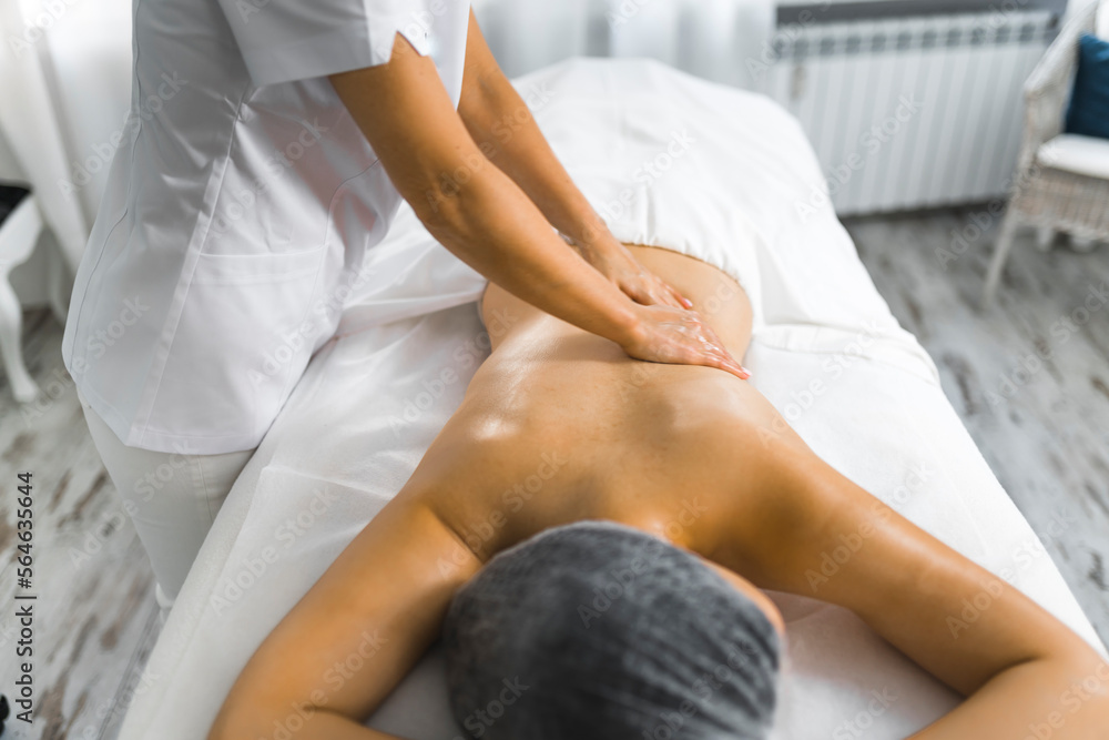 Fototapeta premium Beautiful woman getting a back massage in spa. High quality photo