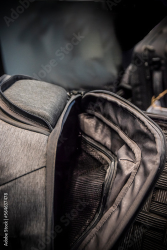 A detail of a modern dark grey half-opened backpack 