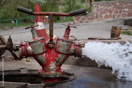 Water flows from faucet and pipe. Draining water from building plumbing system photo