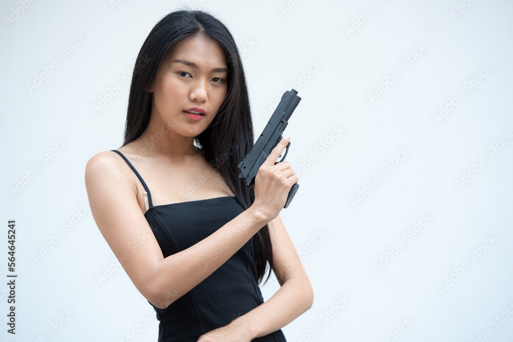 Sexy beauty young woman in black camisole posing with gun on white background. Girl in camisole with gun hand sexy brunette woman gun plain background. Sexy beauty young woman in black camisole posing with gun on white background. Girl in camisole with gun hand sexy brunette woman gun plain background.