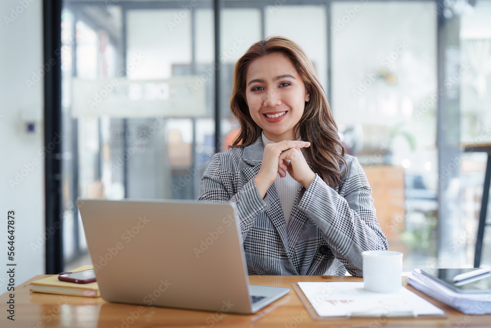 Portrait of Smiling asian business woman with laptop computer in office. Woman in suit at office Portrait of Smiling asian business woman with laptop computer in office. Woman in suit at office