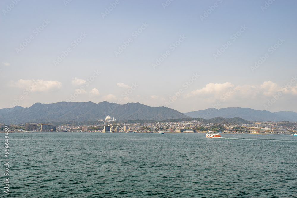 Beautiful landscape of Miyajima city with ferry boat from the island in Hiroshima prefecture.