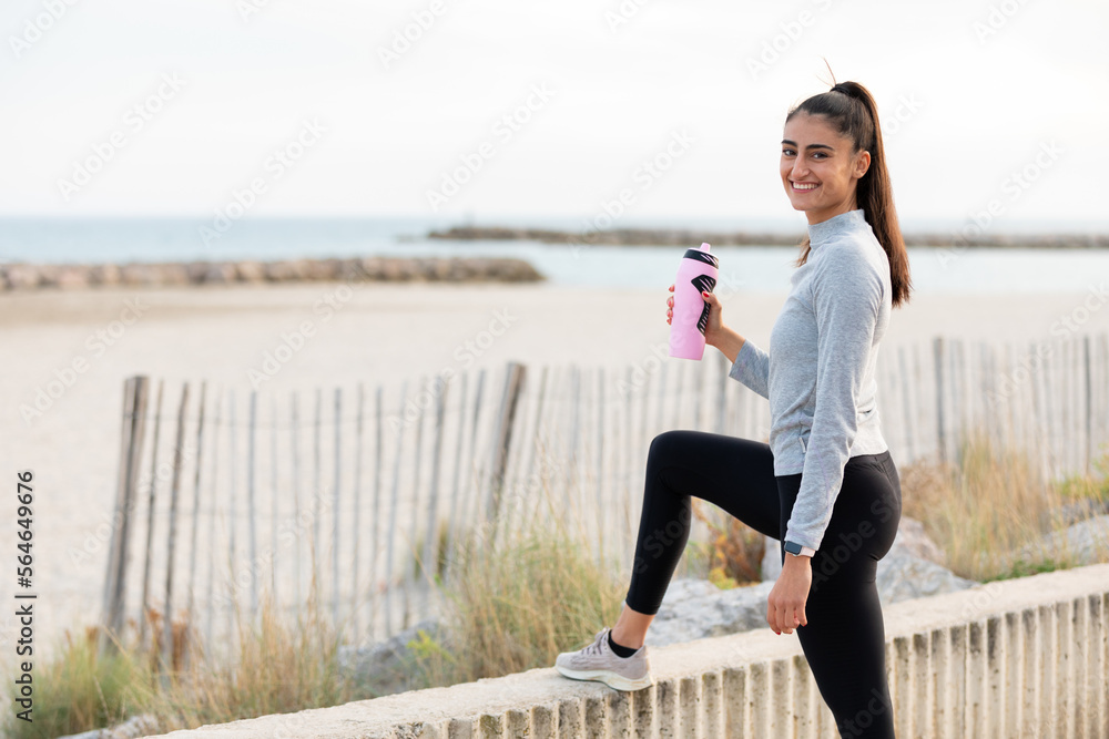 Φωτογραφία jeune femme fait une pause pendant son footing en bord de mer