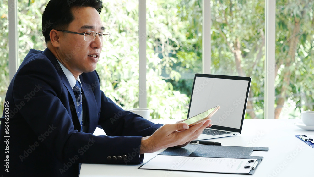 Asian Businessman using laptop at office desk. Man hands typing computer keyboard reading financial graph chart Planning analyzing marketing data. happy Asian business men people working office firm Asian Businessman using laptop at office desk. Man hands typing computer keyboard reading financial graph chart Planning analyzing marketing data. happy Asian business men people working office firm