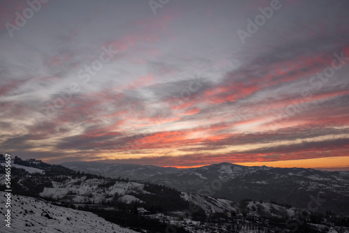 Panorama of a sunset in the italian countryside covered in snow