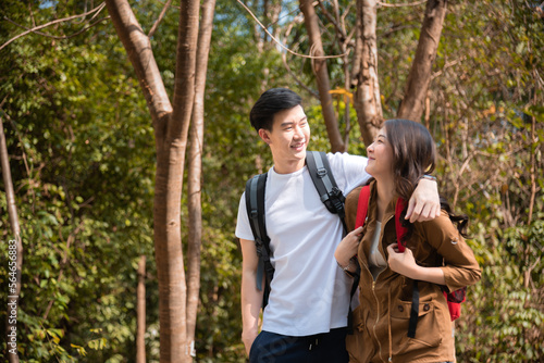 Young Asian couples have fun together in park, tourist outdoor adventure trip lifestyle spend time together trekking in forest during vacation or holiday, Adorable girl have happy time with boyfriend