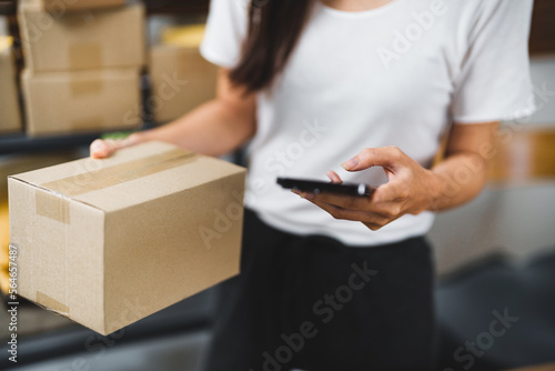 Small Asian business owner packing in the cardbox preparing parcel for delivery online selling sell Online on the Internet from home
