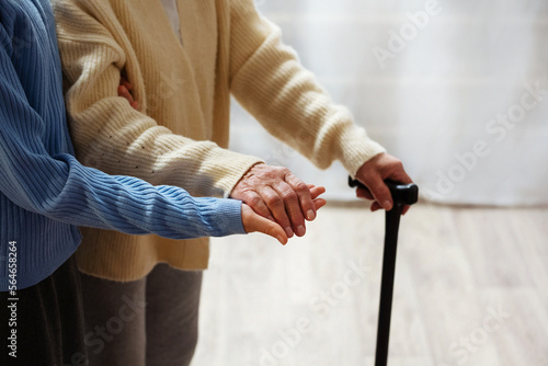 Old woman in a nursing facility receives help from a hospital staff nurse. Senior woman, aged wrinkled skin and her hands caring for her. Background, copy space, close up