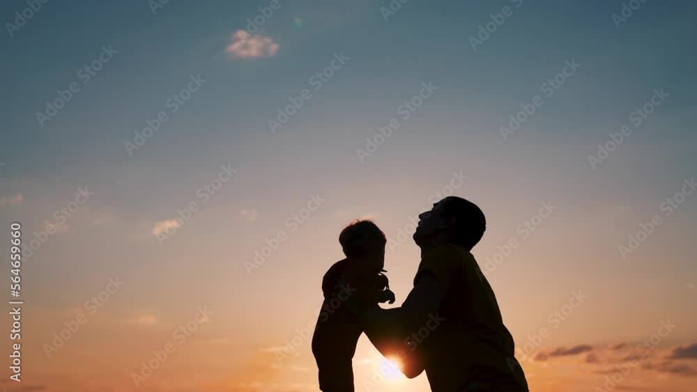 Fatherhood concept. Silhouette of father, child against background of sky. loving father spends time with child, picks him up, expresses love, feels affection, looks happy. Happy family spend time. Fatherhood concept. Silhouette of father, child against background of sky. loving father spends time with child, picks him up, expresses love, feels affection, looks happy. Happy family spend time.