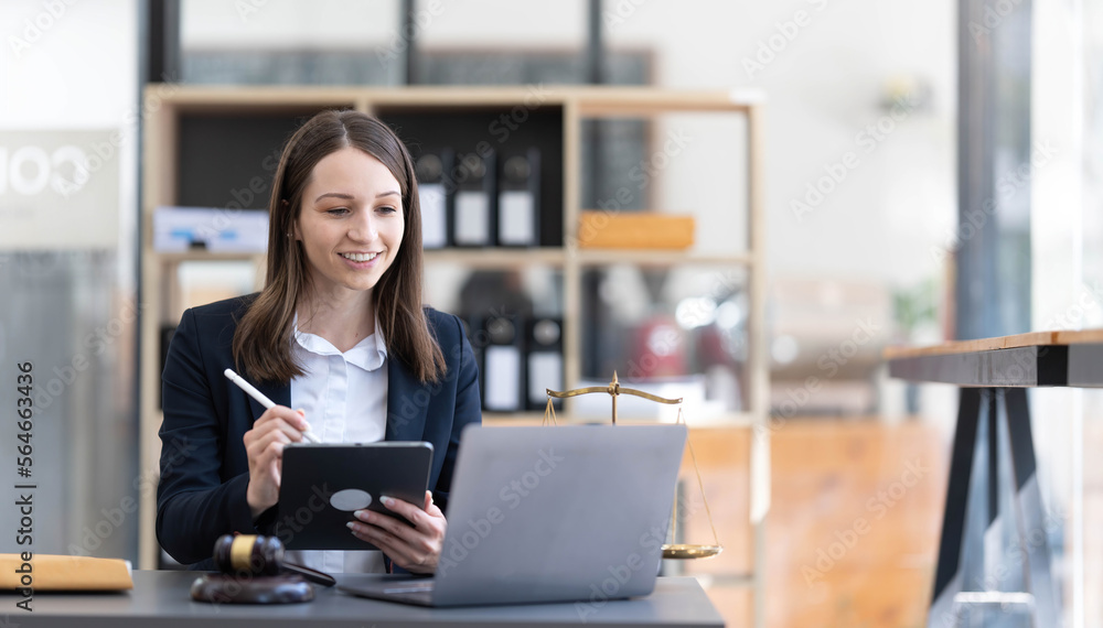 Fototapeta premium Justice Attorney's Office with Scales and Female Lawyer Working on Laptop, Advice and Justice Lawyer discussing contract documents in the office. legal services real estate ideas advice