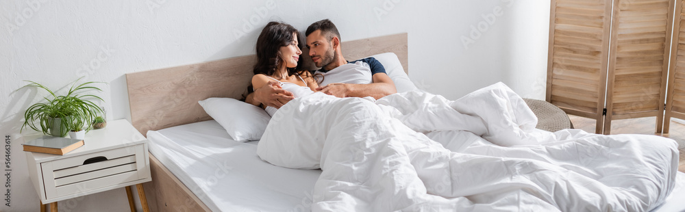 Young man hugging girlfriend on bed in morning, banner. Young man hugging girlfriend on bed in morning, banner.