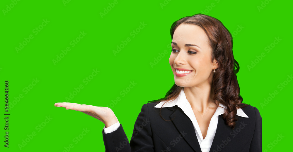 Portrait image of happy smiling business woman in black confident suit showing, giving, holding, advertising. Executive, teacher or real estate agent. Green chroma key background. Portrait image of happy smiling business woman in black confident suit showing, giving, holding, advertising. Executive, teacher or real estate agent. Green chroma key background.