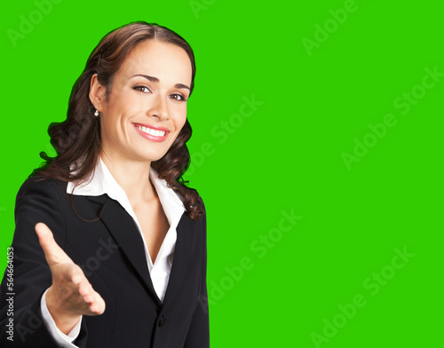 Portrait image of happy smiling business woman in black confident suit giving hand for handshake. Female executive office worker, teacher or real estate agent. Green chroma key background.