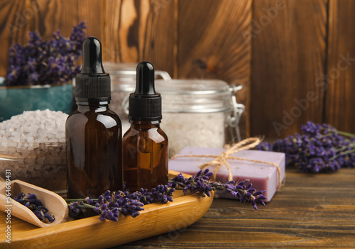 Lavender spa.Cosmetic products sea salt,body cream,handmade soap,scrub,essential oils and lavender flowers on brown wood.Natural herb cosmetic with lavender flowers. Beauty concept. copy space