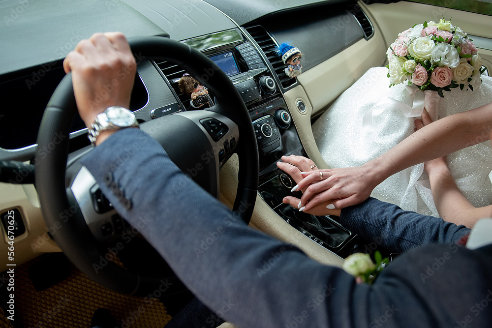 bride and groom holding hands while sitting in the car on their wedding ...