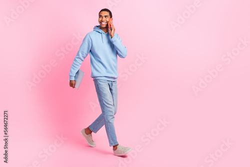 Full length photo of successful businessman wear stylish clothes go modern device shop look empty space isolated on pink color background