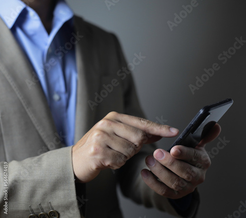 businessman using mobile smart phone on dark background