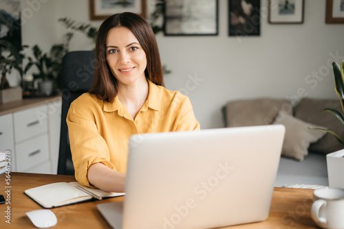 Young happy smiling professional business woman, female company worker or corporate manager posing in modern office working, looking at camera, portrait.