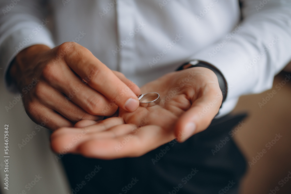 Man holding two wedding rings in his hands