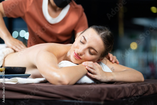 Back spa massage. Beautiful cuacasian female getting massage in beauty spa and wellness center. Facial treatment and skin care concept.