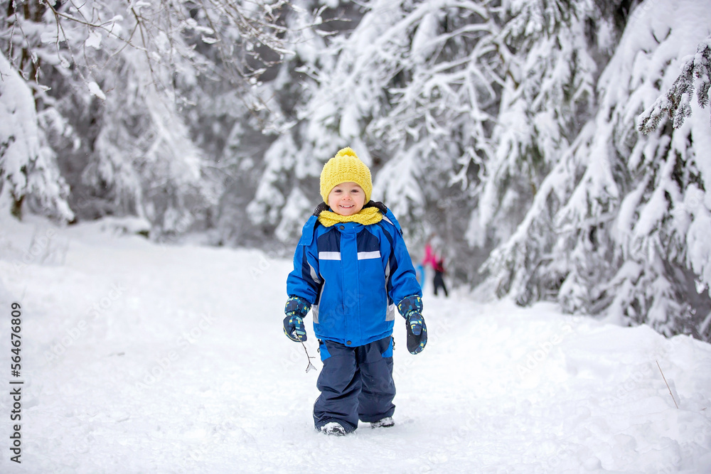 Sweet happy child, playing in deep snow