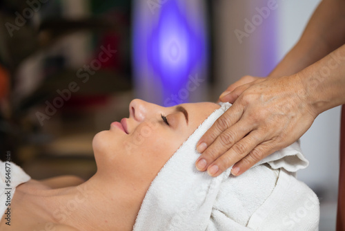 happy beautiful caucasian woman enjoying head massage at the spa and wellness center