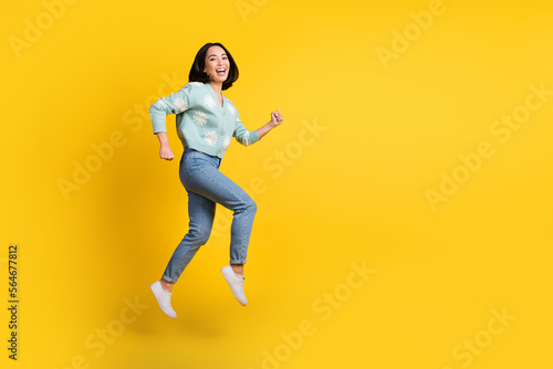 Full length photo of cute optimistic cheerful girl dressed blue cardigan jeans running on sale isolated on yellow color background