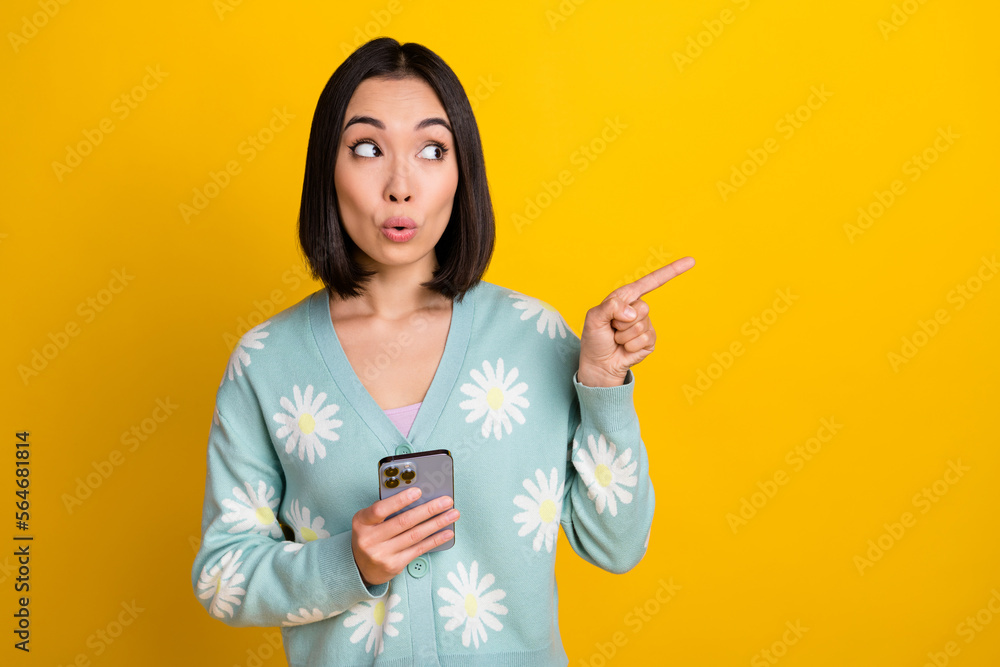 Photo of impressed woman hold phone look indicating empty space instagram facebook twitter whatsapp isolated on yellow color background Photo of impressed woman hold phone look indicating empty space instagram facebook twitter whatsapp isolated on yellow color background