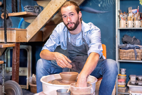 Man potter learning pot making ceramic clay objects on bench work in pottery workshop