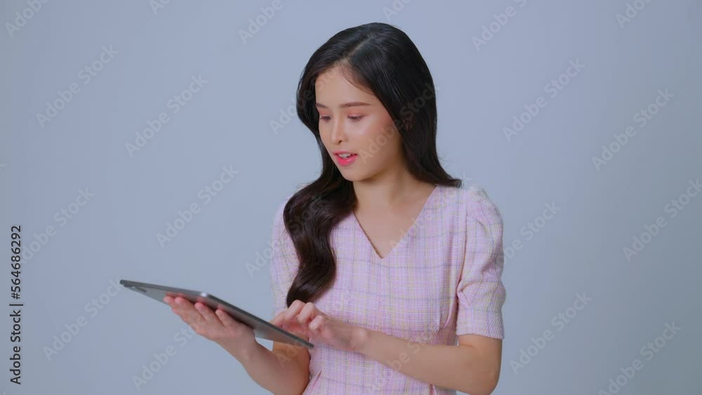 Closeup happy woman face looking tablet screen. Smiling young businesswoman posing on black-gray background studio. Shopping on laptop showing thumb up. Laugh and enjoy. Closeup happy woman face looking tablet screen. Smiling young businesswoman posing on black-gray background studio. Shopping on laptop showing thumb up. Laugh and enjoy.