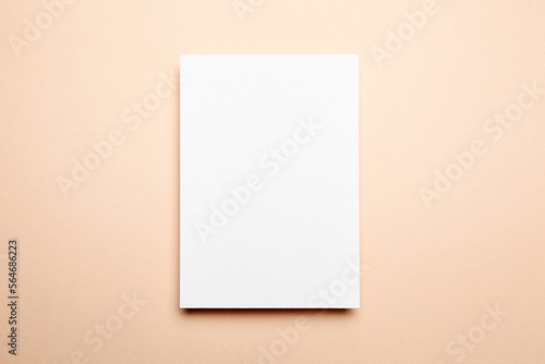 Greeting card mockup beige background, top view, flat lay. Blank holiday card or flyer