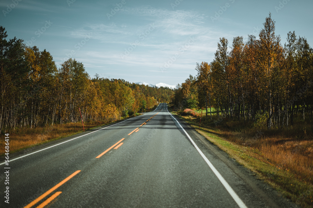 Empty road with a view on majestic mountains and the norwegian landscape in autumn