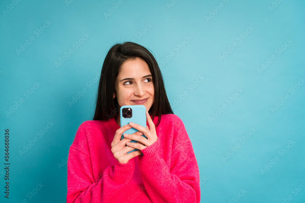Fototapeta premium Young woman with smartphone in studio